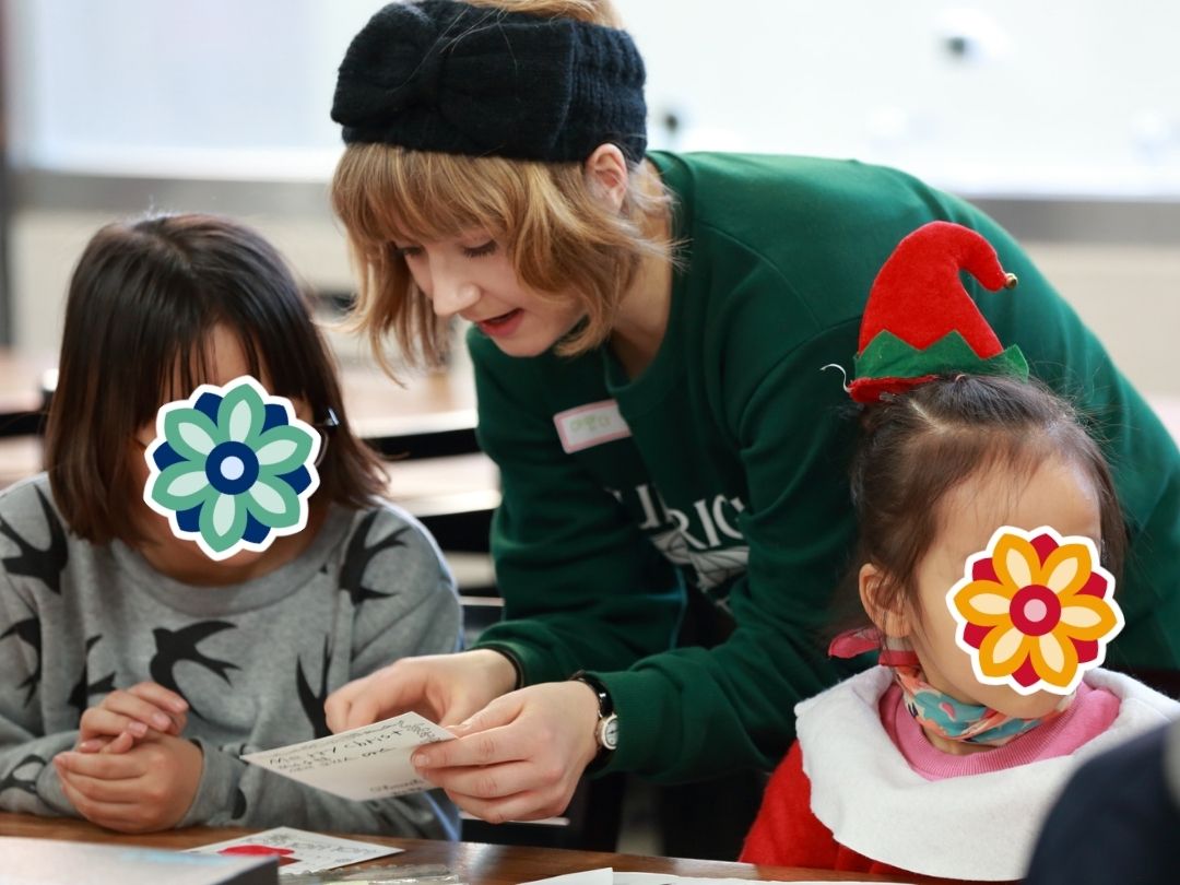 Volunteer helping children with a holiday craft project.