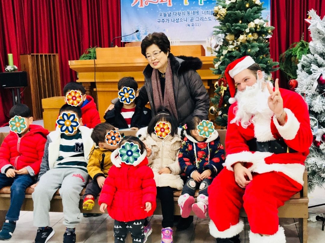 Children sitting with Santa during a KKOOM holiday celebration.