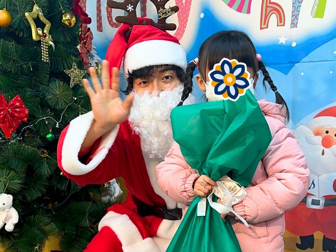 Santa giving gifts to children during a KKOOM holiday celebration.