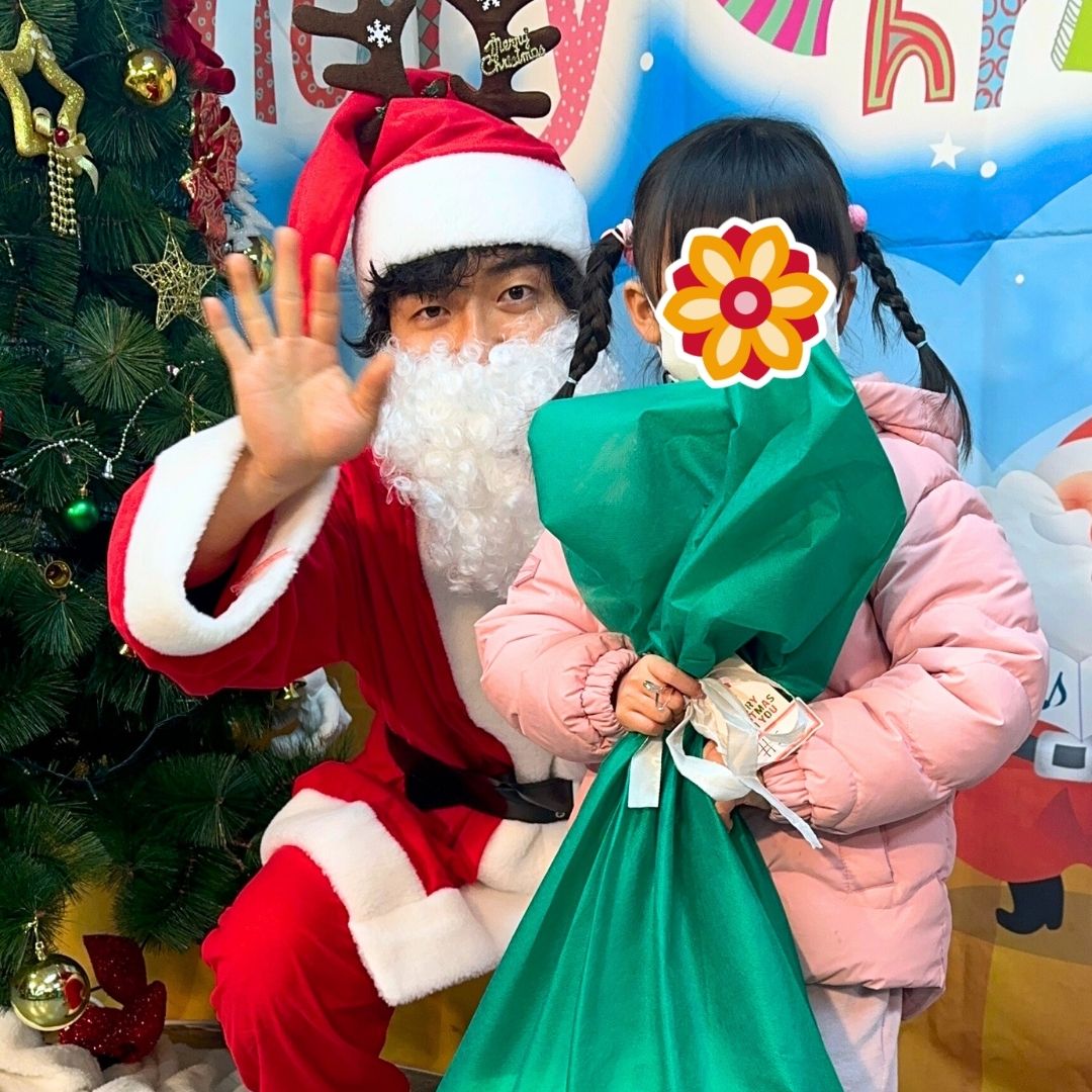 Child receiving a holiday gift from Santa during a KKOOM Christmas party.