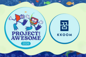 Graphic featuring the Project for Awesome 2026 logo on the left, with illustrated characters snorkeling and holding a camera, and the KKOOM logo on the right. The two circular logos are displayed side by side on a light blue and green, ocean-themed background with fish and water patterns.