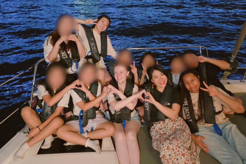 KKOOM staff and youth gathered together on a boat at night during the Busan Sports and Wellness Camp near Gwangalli BeachKKOOM staff and youth gathered together on a boat at night during the Busan Wellness Camp near Gwangalli Beach.