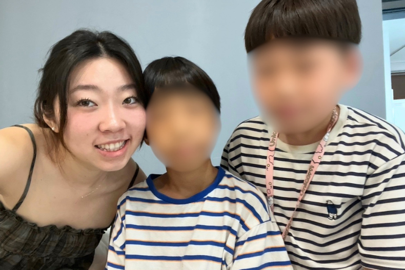 Yumin smiling with a young participants during a camp activity in Korea.
