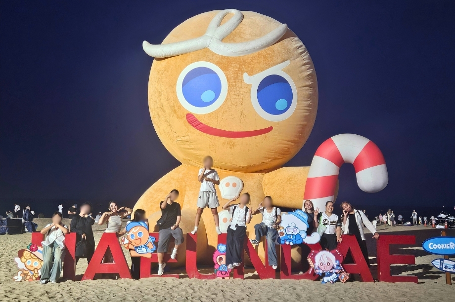 KKOOM volunteers and students posing on Haeundae Beach in Busan during the 2026 GEM Program Wellness Camp.