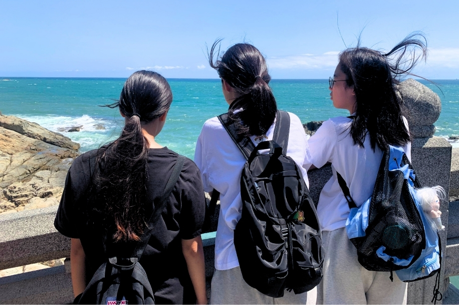 Students walking along the coast near Haedong Yonggungsa Temple during KKOOM's Busan Wellness Camp.
