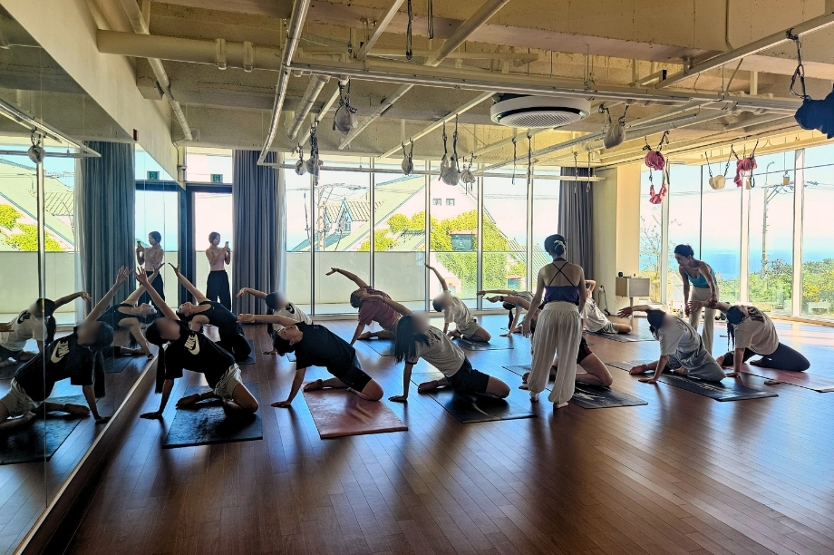 GEM Program students and volunteers practicing yoga together during KKOOM's Busan Wellness Camp.