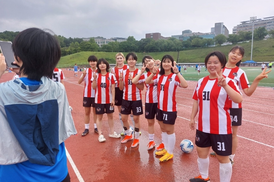 Vivian and her Korea University Women’s Football Club teammates posing on the soccer field.